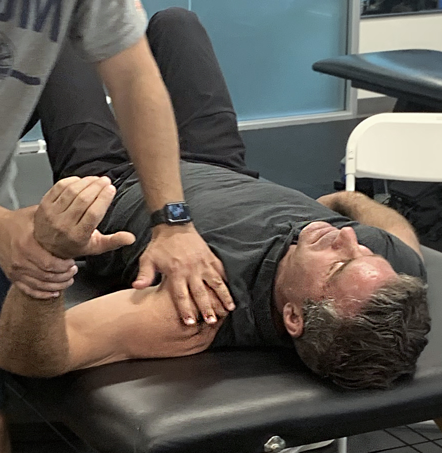 man lying down to have a shoulder therapy