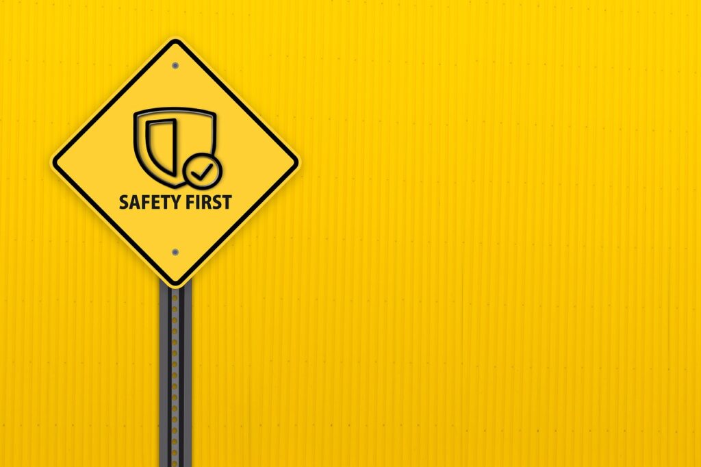 road warning sign on post saying "safety first" with shield icon.