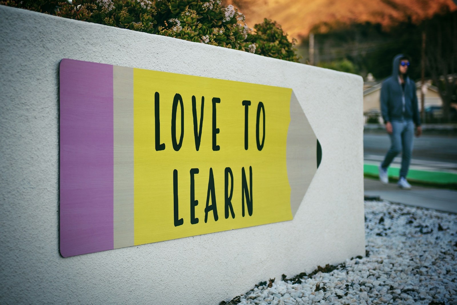 sign in the shape of a pencil saying "love to learn"